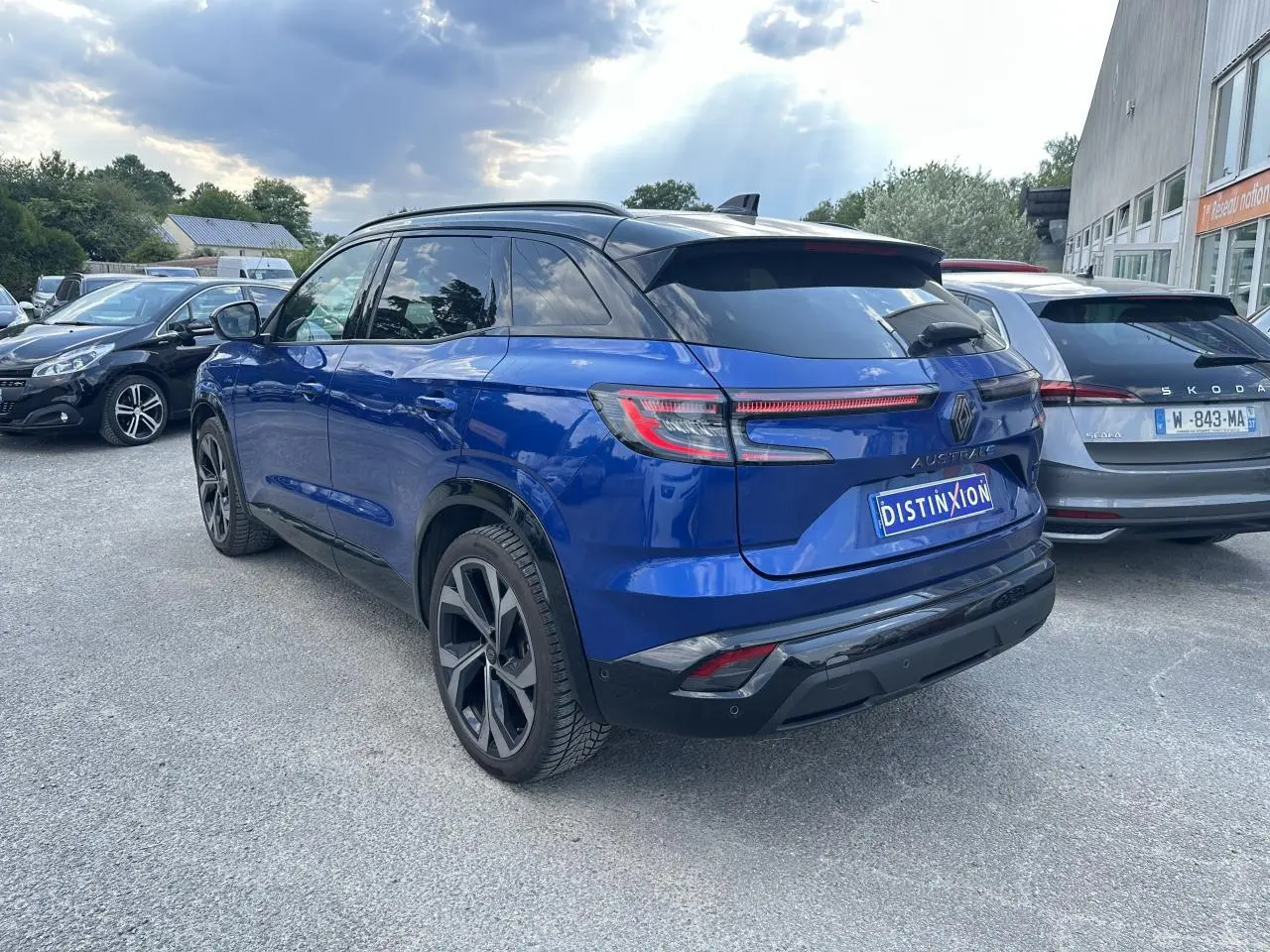 Vue 3/4 arrière droite du Renault Austral hybride bleu avec toit noir et feux arrière LED à effet 3D.