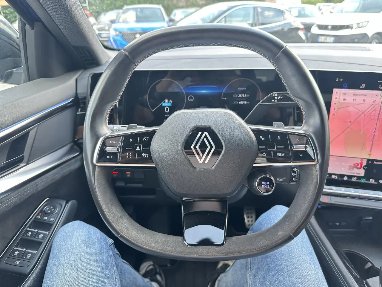 Vue intérieure centrée sur le volant multifonction noir du Renault Austral 2024 avec tableau de bord numérique et écran tactile.