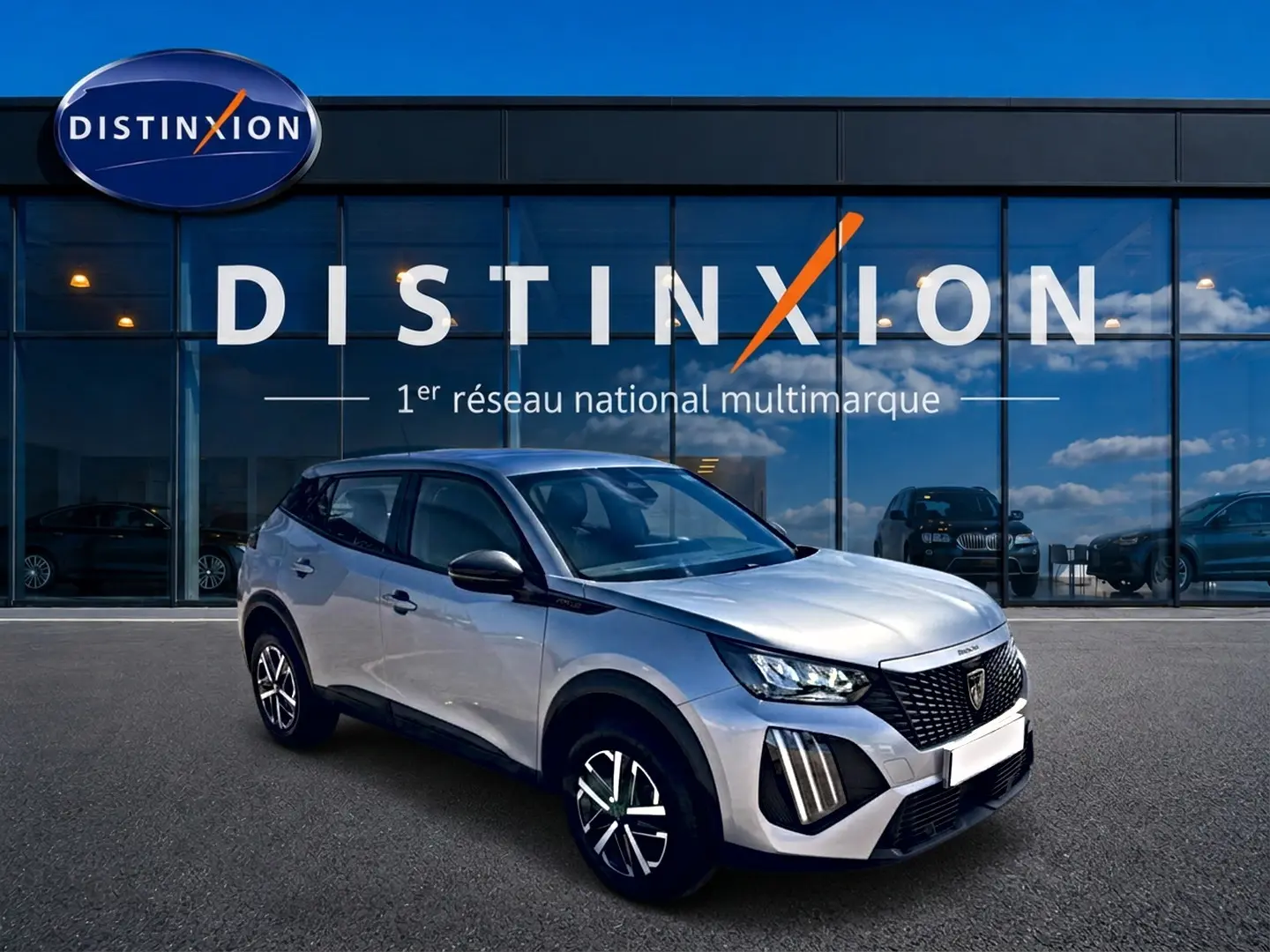 Peugeot 2008 gris 3/4 avant droit avec jantes distinctives et toit noir devant vitrine Distinxion.