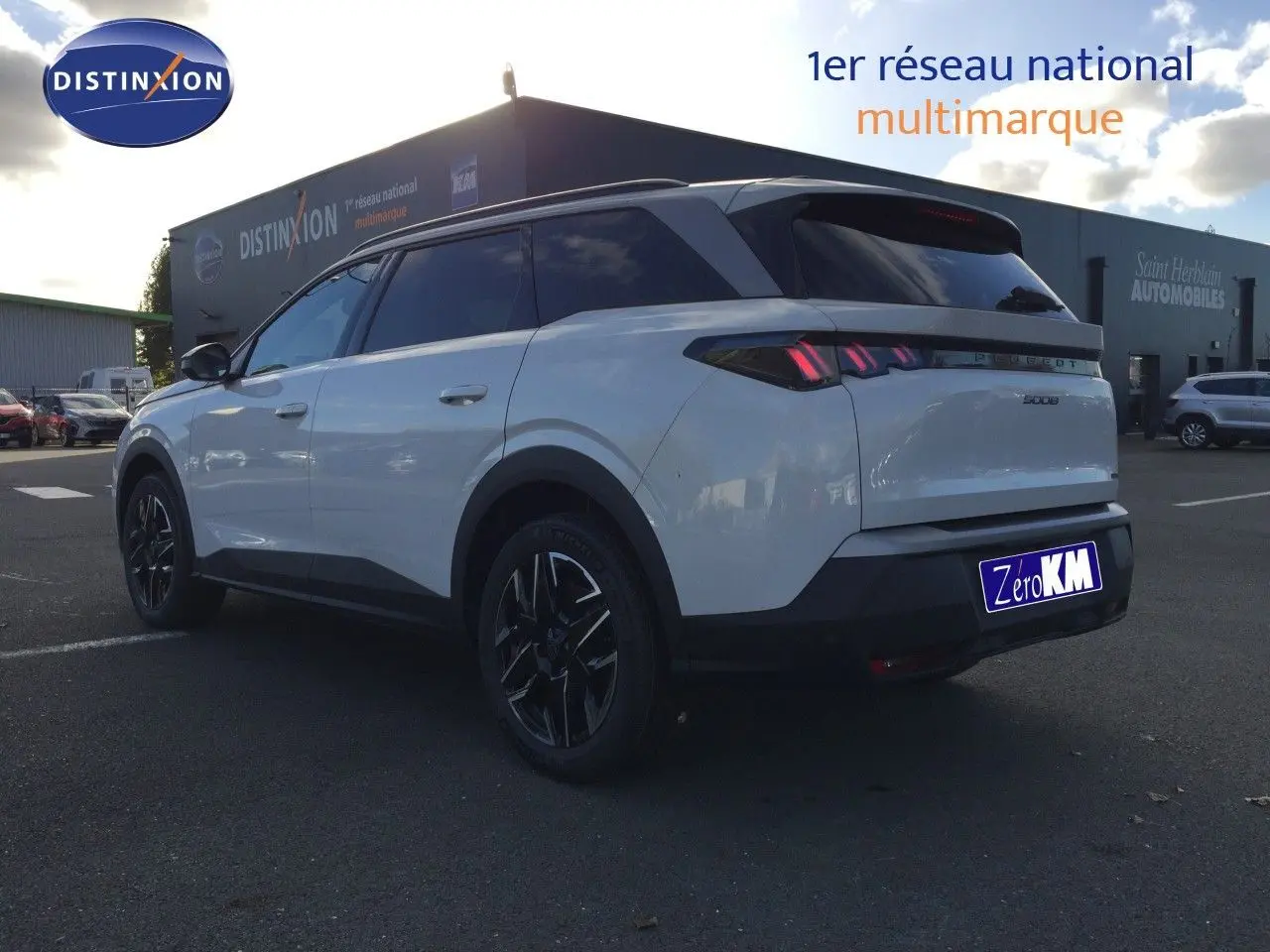 Peugeot 5008 blanc Okenite métal vu de trois quarts arrière droit, avec feux arrière LED et jantes noires distinctives.