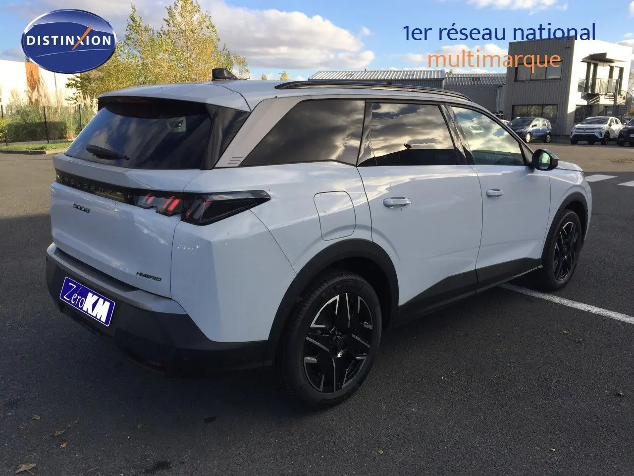 Peugeot 5008 Hybrid blanc Okenite métal vu en 3/4 arrière droit, avec jantes noires et vitres teintées.