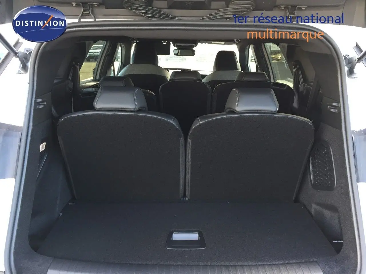 Vue arrière du coffre ouvert du Peugeot 5008 blanc Okenite Metal, montrant les sièges arrière en position verticale.