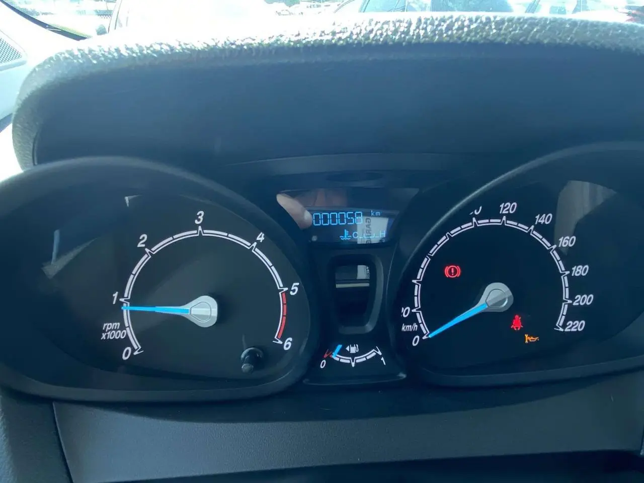 Vue rapprochée du tableau de bord du Ford Tourneo Courier blanc 2022, affichant compte-tours et vitesse à zéro.