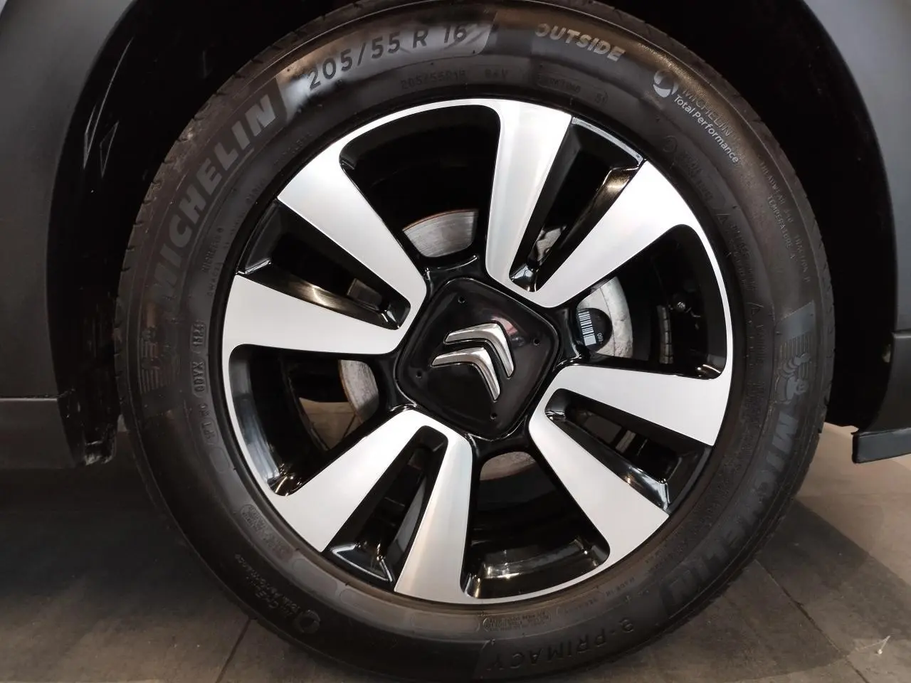 Gros plan sur la jante alliage diamantée 16 pouces noire et argentée de la Citroën C3 gris foncé.