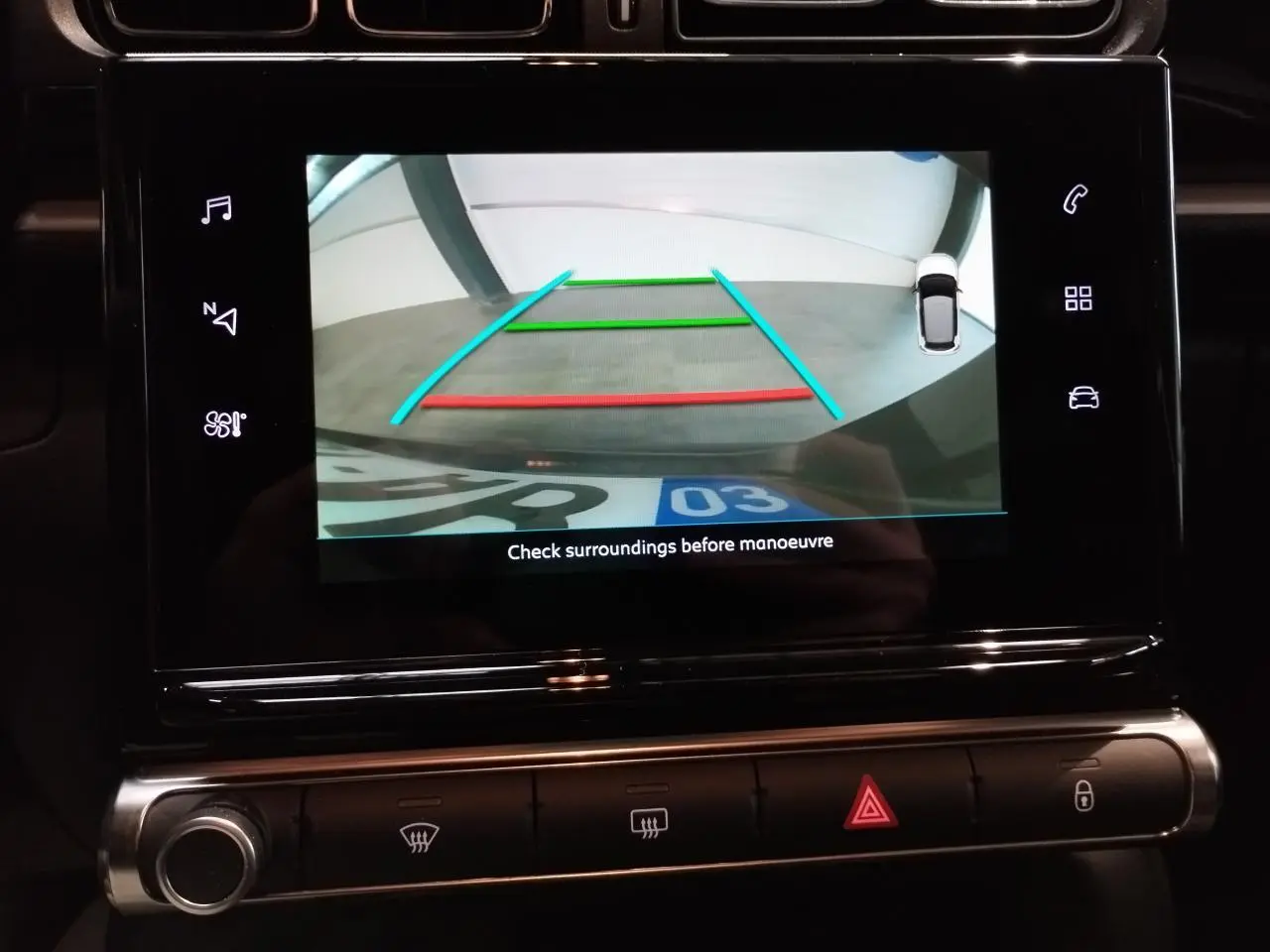Écran tactile intérieur de la Citroën C3 gris foncé montrant la caméra de recul avec guidage coloré.