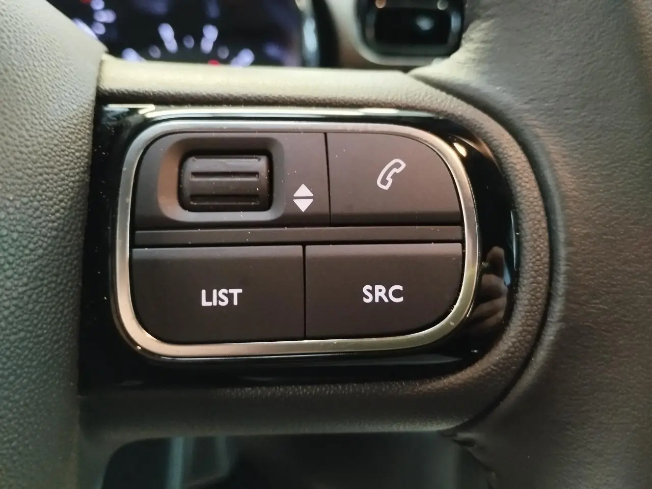 Gros plan sur les commandes audio au volant de la Citroën C3 2024, finition noire avec contour chromé.