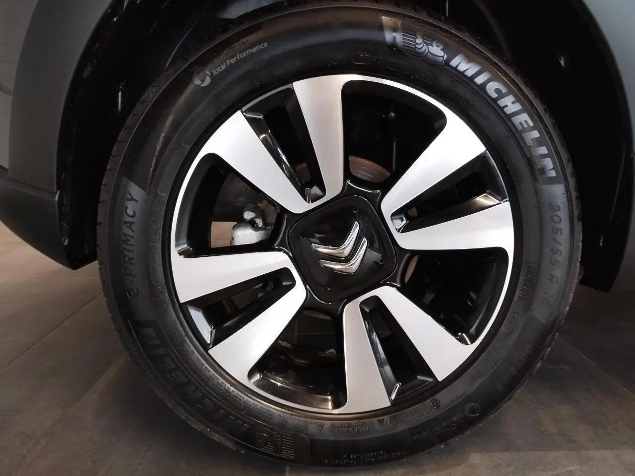 Gros plan sur la jante alliage 16 pouces diamantée noire et argentée d'une Citroën C3 gris foncé.