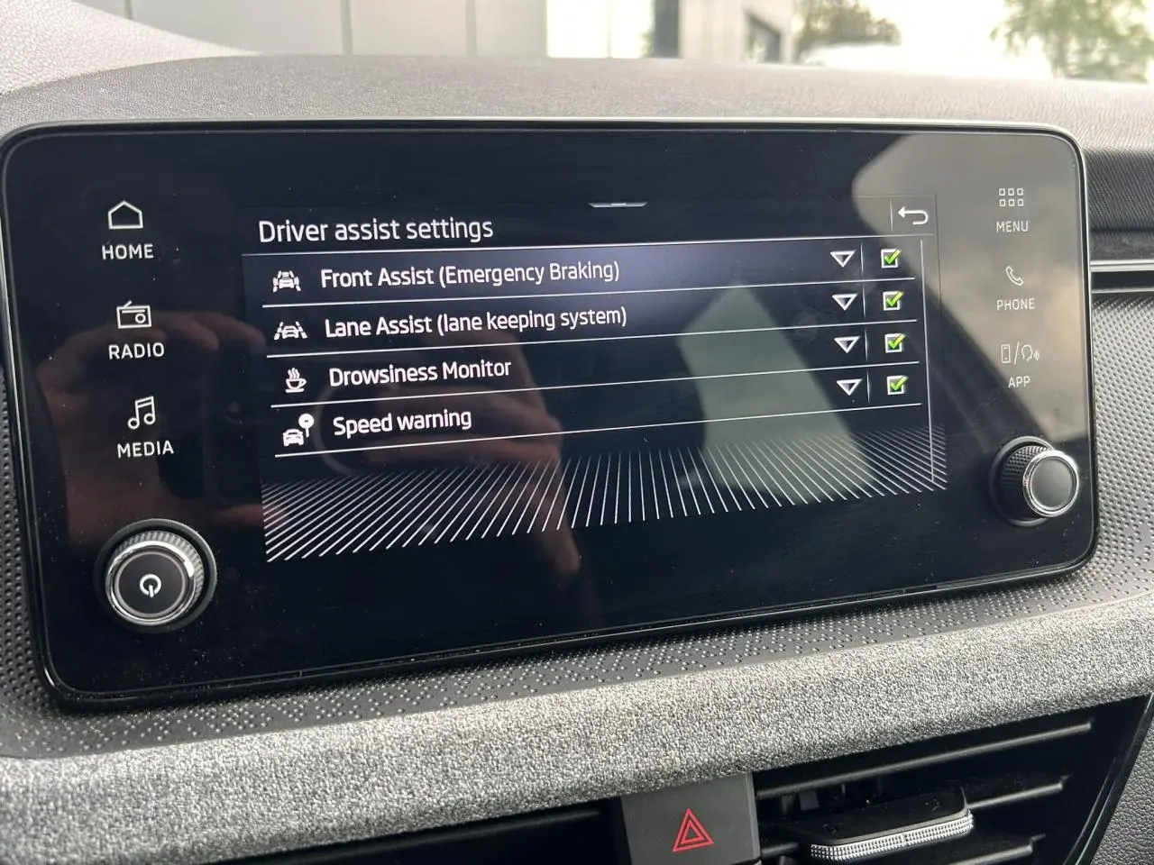 Écran tactile intérieur du Skoda Scala affichant les réglages d'aides à la conduite en mode nuit.