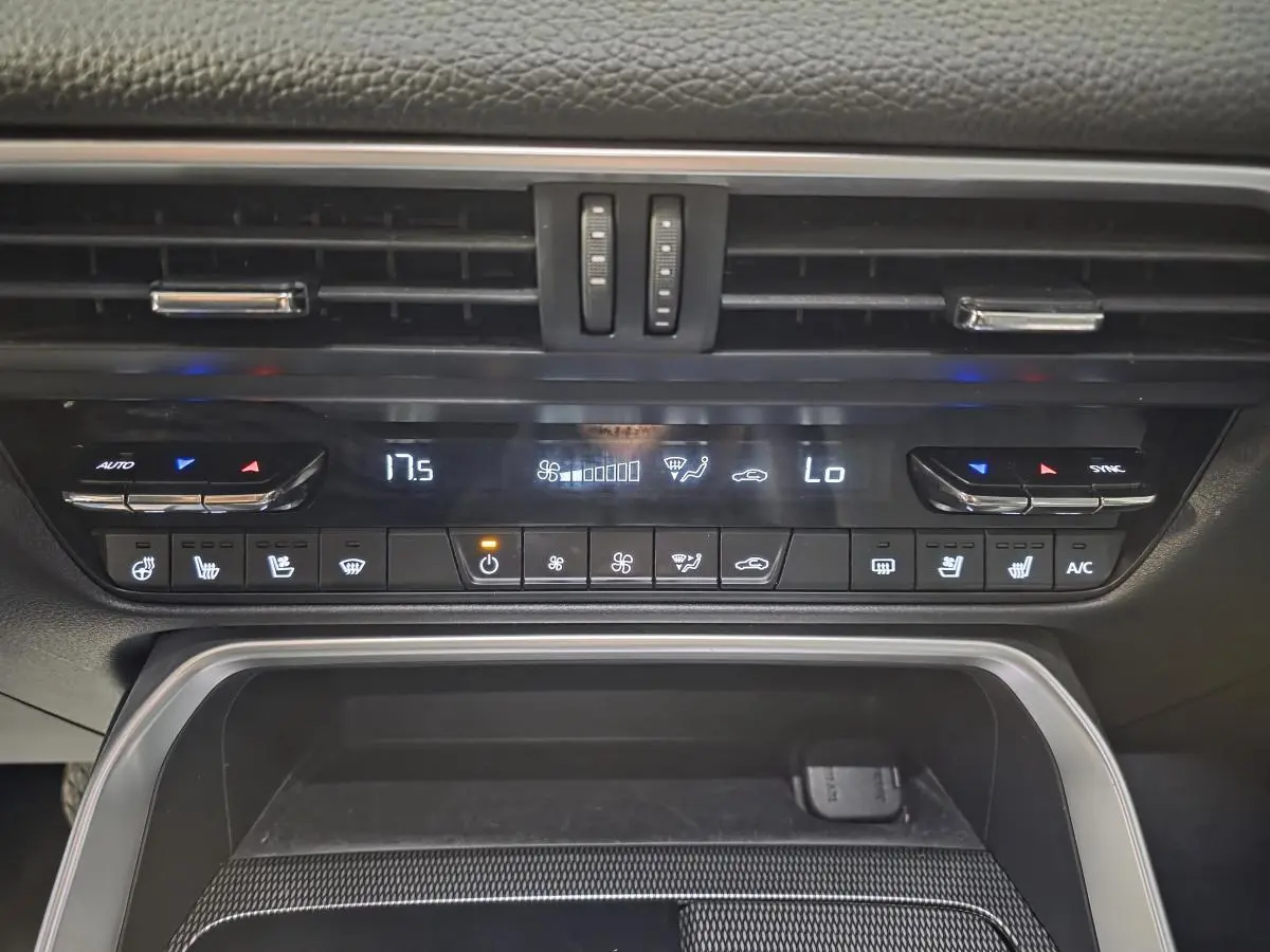 Vue rapprochée de la console centrale du Mazda CX-60 gris, montrant les commandes de climatisation et les aérateurs.