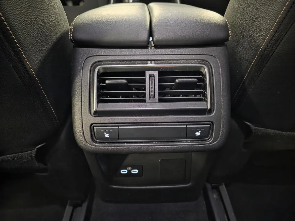 Vue rapprochée de la console arrière noire du Mazda CX-60 gris avec aérateurs, commandes de sièges chauffants et prises USB-C.