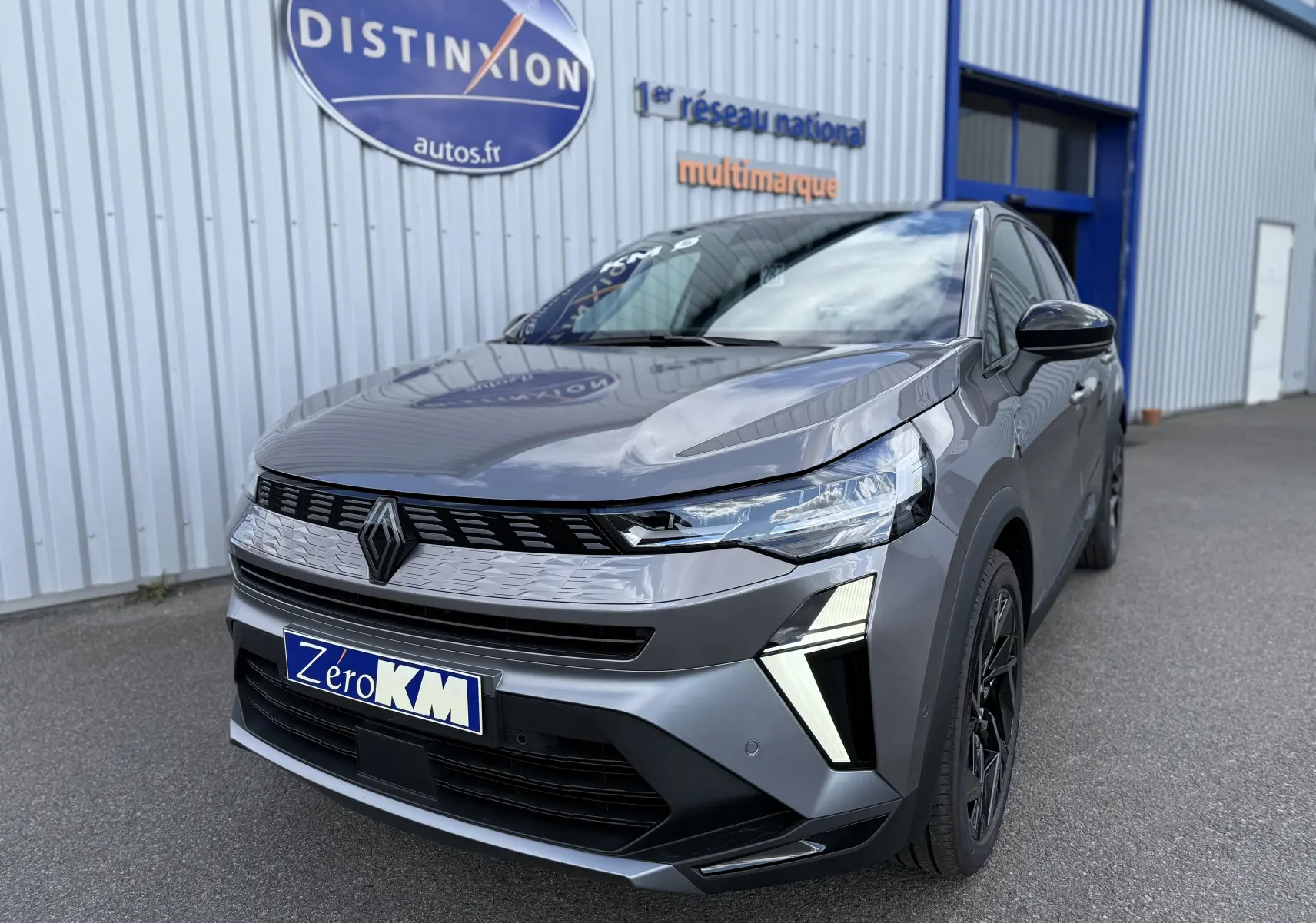 Vue 3/4 avant droite d’un Renault Symbioz gris Cassiopée métallisé avec signature lumineuse distinctive et jantes noires.