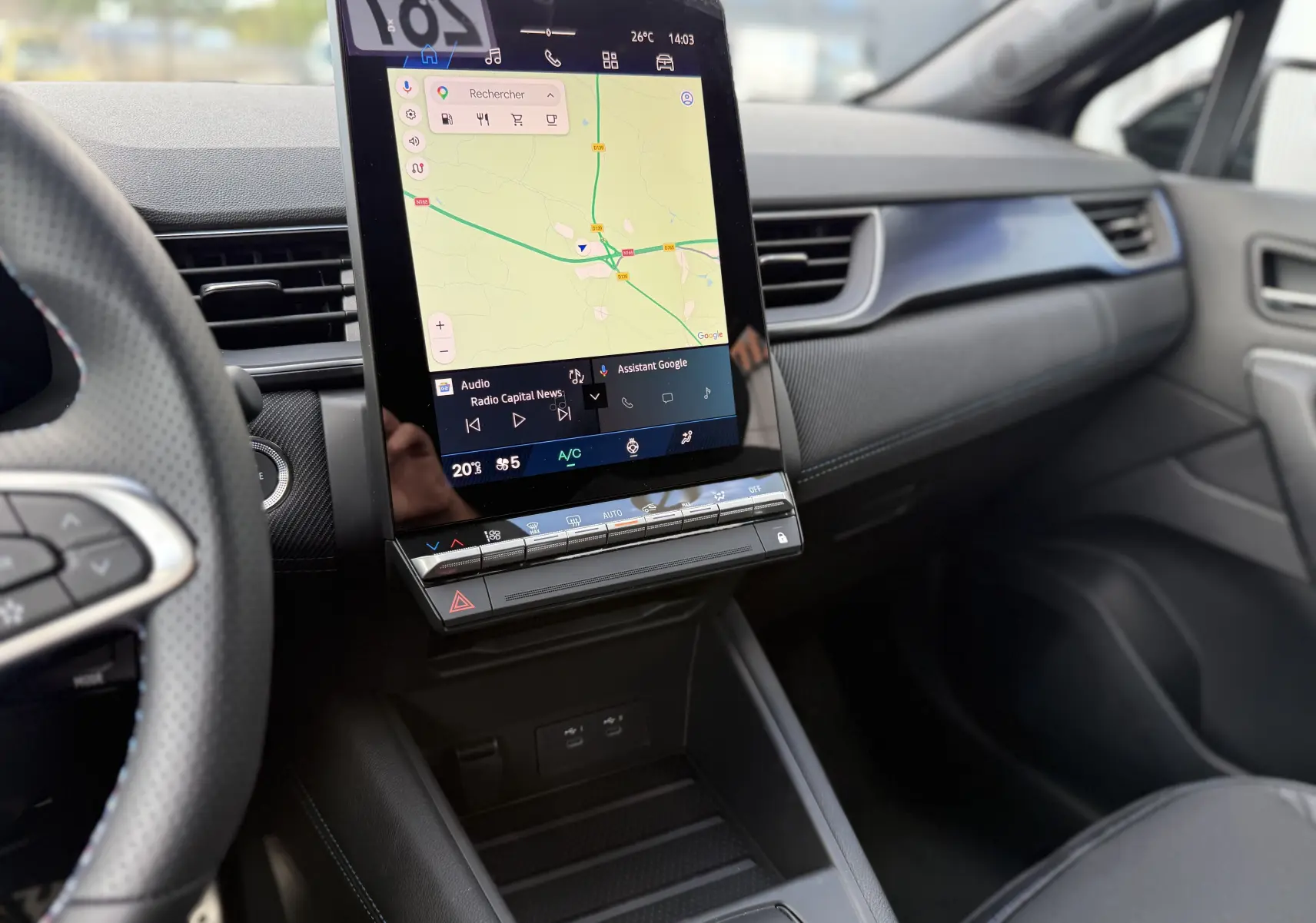 Vue intérieure du tableau de bord de la Renault Symbioz gris cassiopée, avec écran tactile vertical affichant la navigation.