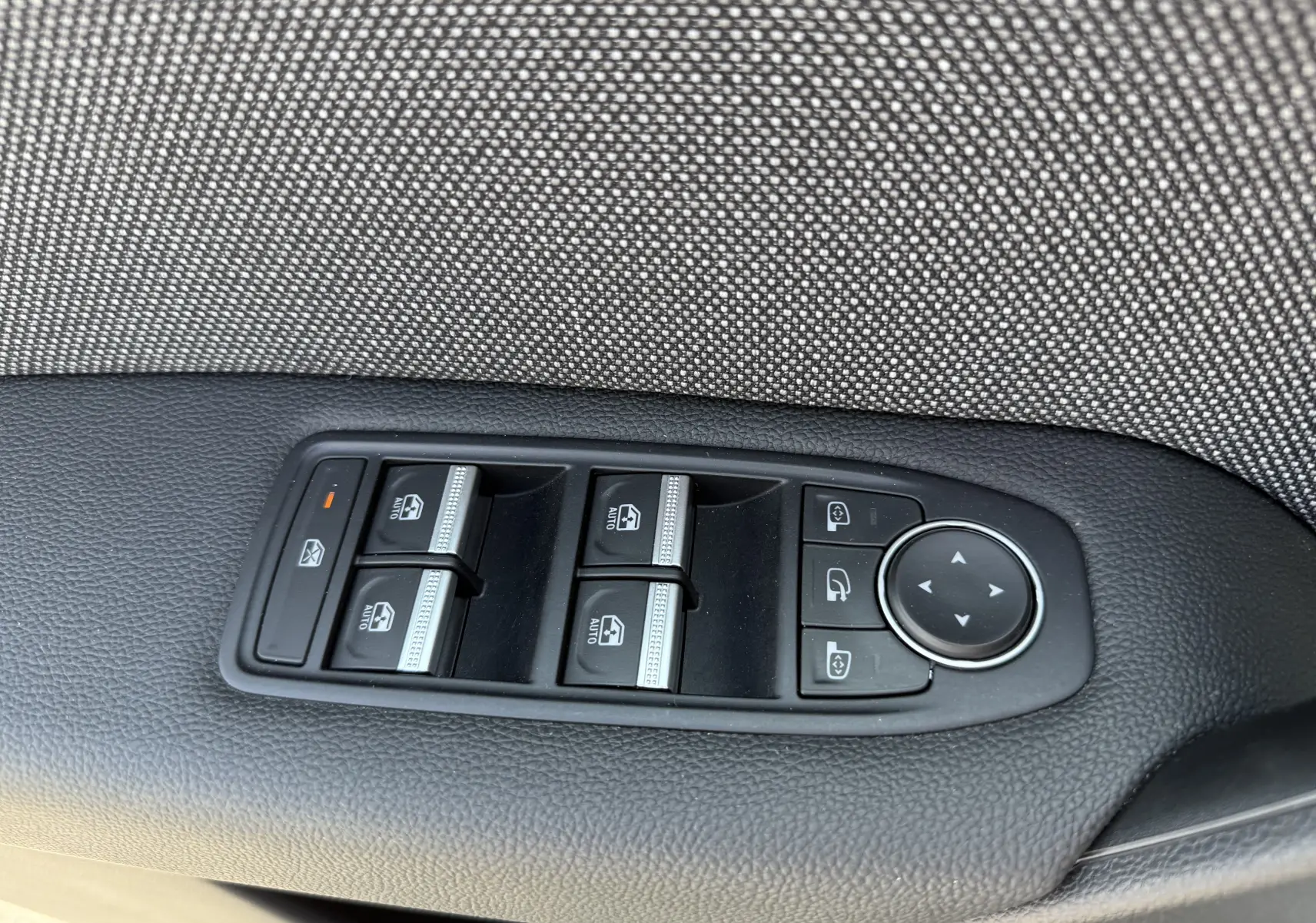 Commande des vitres électriques et réglage des rétroviseurs sur la porte côté conducteur d’un Renault Captur gris Rafale toit noir.