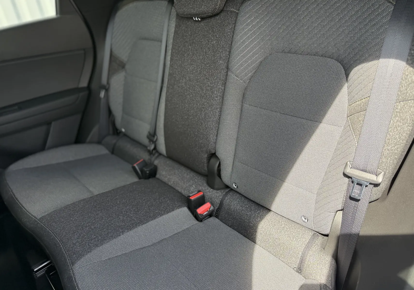 Vue rapprochée des sièges arrière gris du Renault Captur 2025 avec ceintures de sécurité visibles.