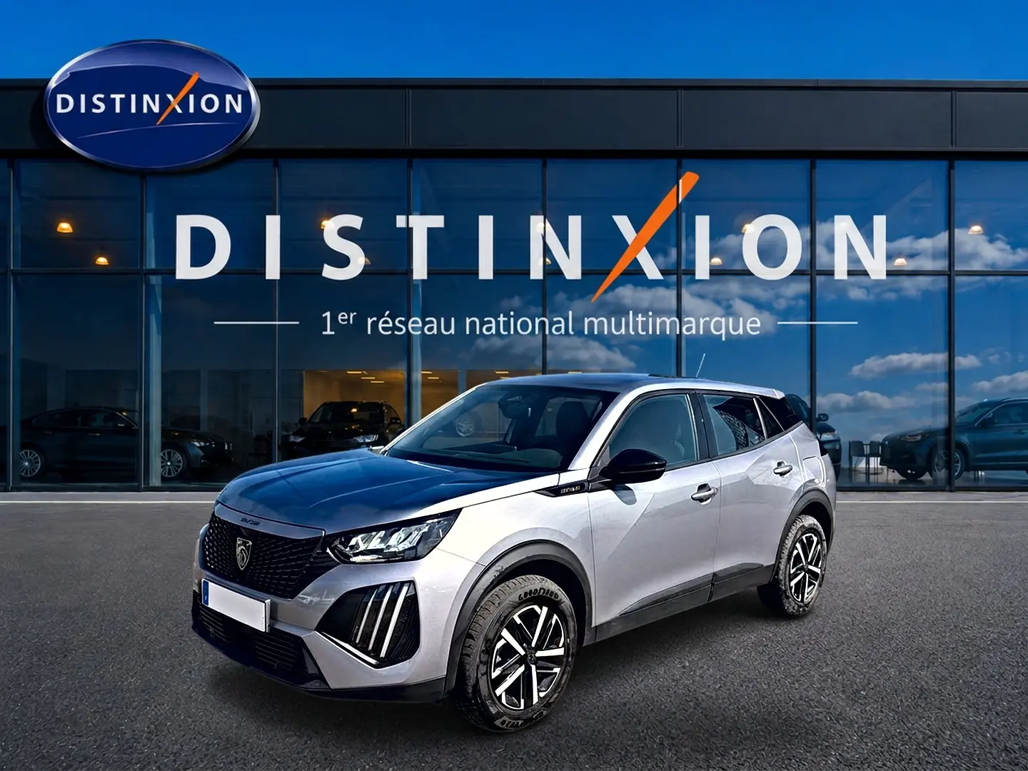 Peugeot 2008 gris 3/4 avant droit avec toit noir et jantes distinctives, devant showroom Distinxion.