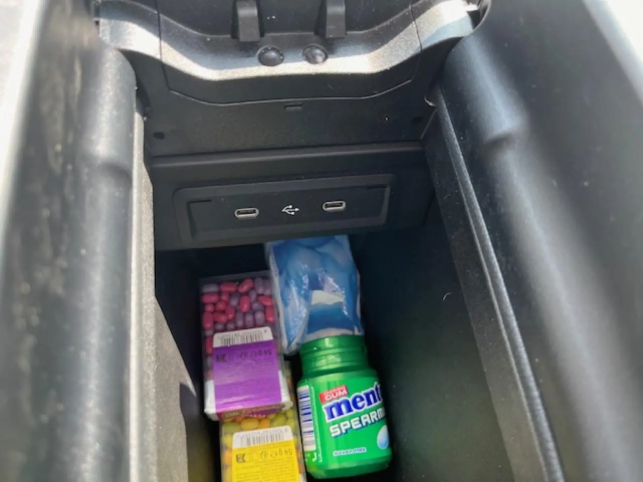 Gros plan sur la console centrale d'une Mercedes GLA 250 e blanche, montrant deux ports USB-C dans le rangement.