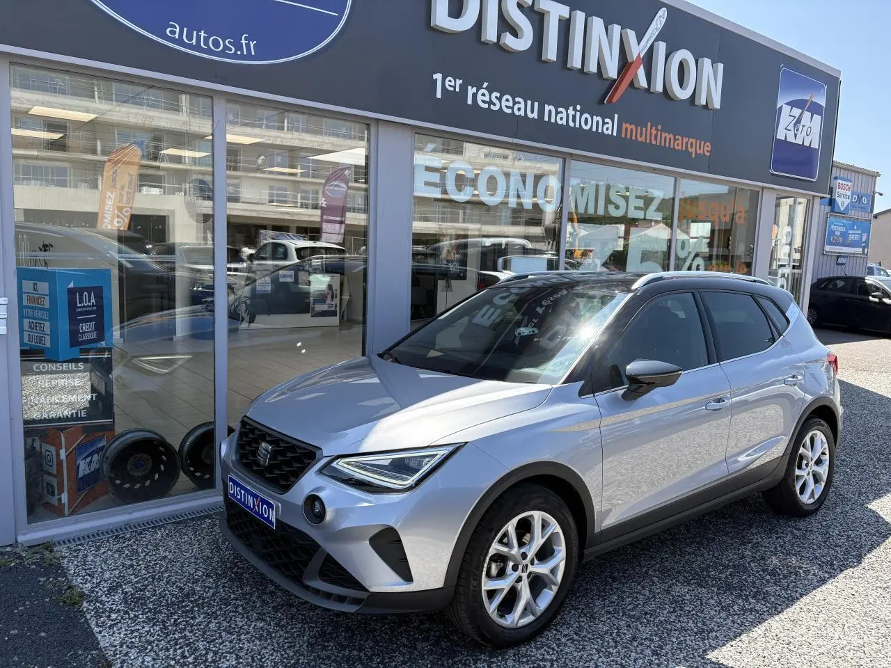 SEAT Arona 2024 gris GRS en 3/4 avant droit, avec jantes alliage 16 pouces et calandre noire satinée.