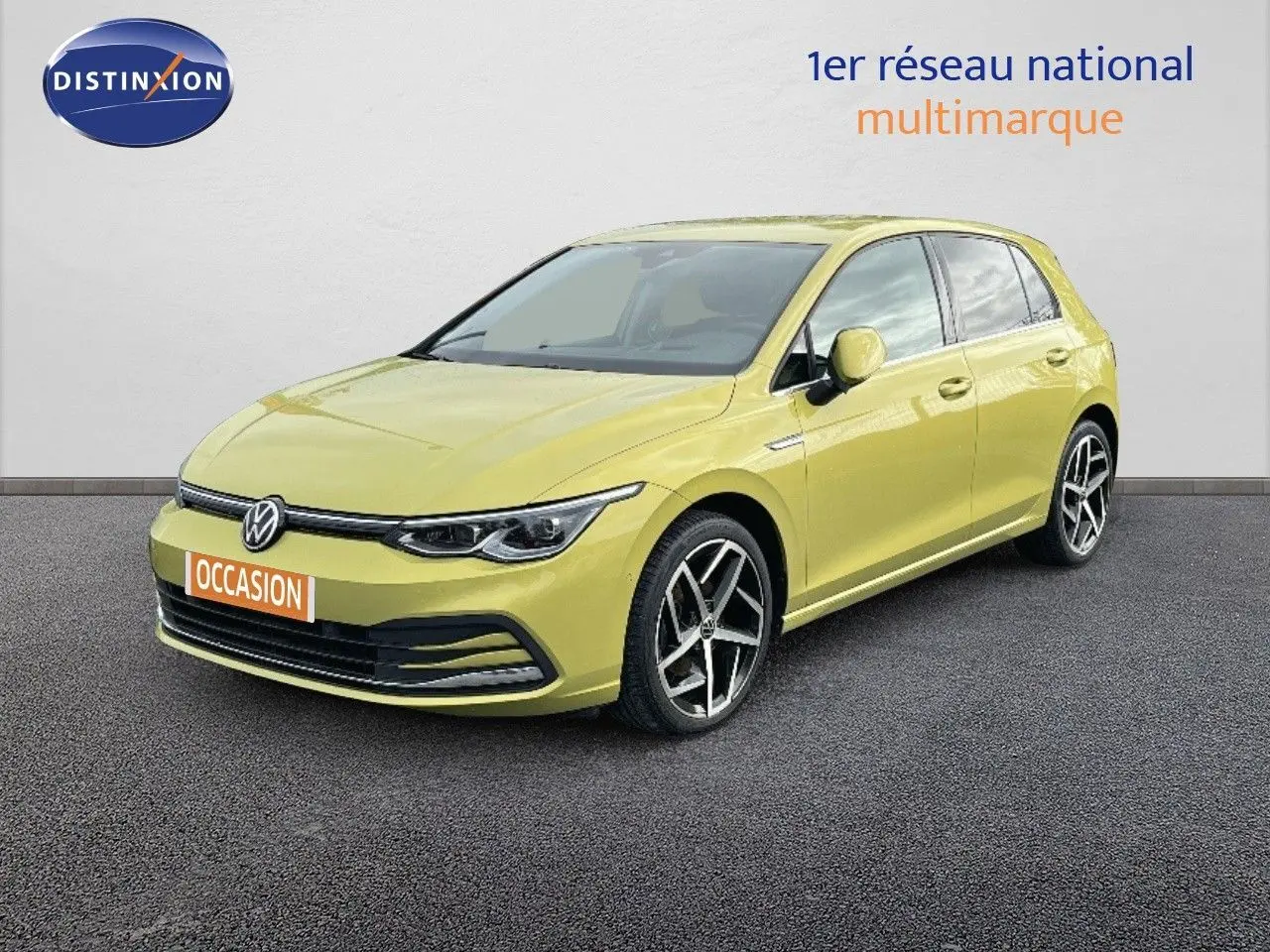Volkswagen Golf 1.5 eTSI jaune vue 3/4 avant droit sur sol gris devant un mur blanc.