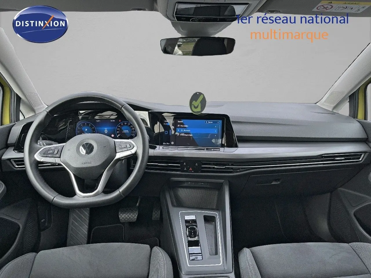Intérieur moderne de Volkswagen Golf jaune 2020, vue frontale sur tableau de bord et volant multifonction noir.