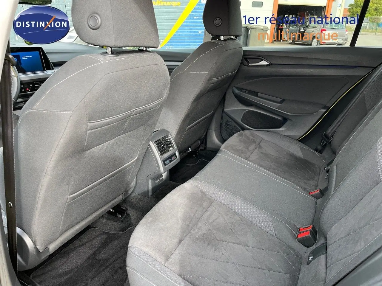Vue arrière de l'intérieur de la Volkswagen Golf jaune 1.5 eTSI 2020, sièges tissu gris et console centrale avec aérateurs.