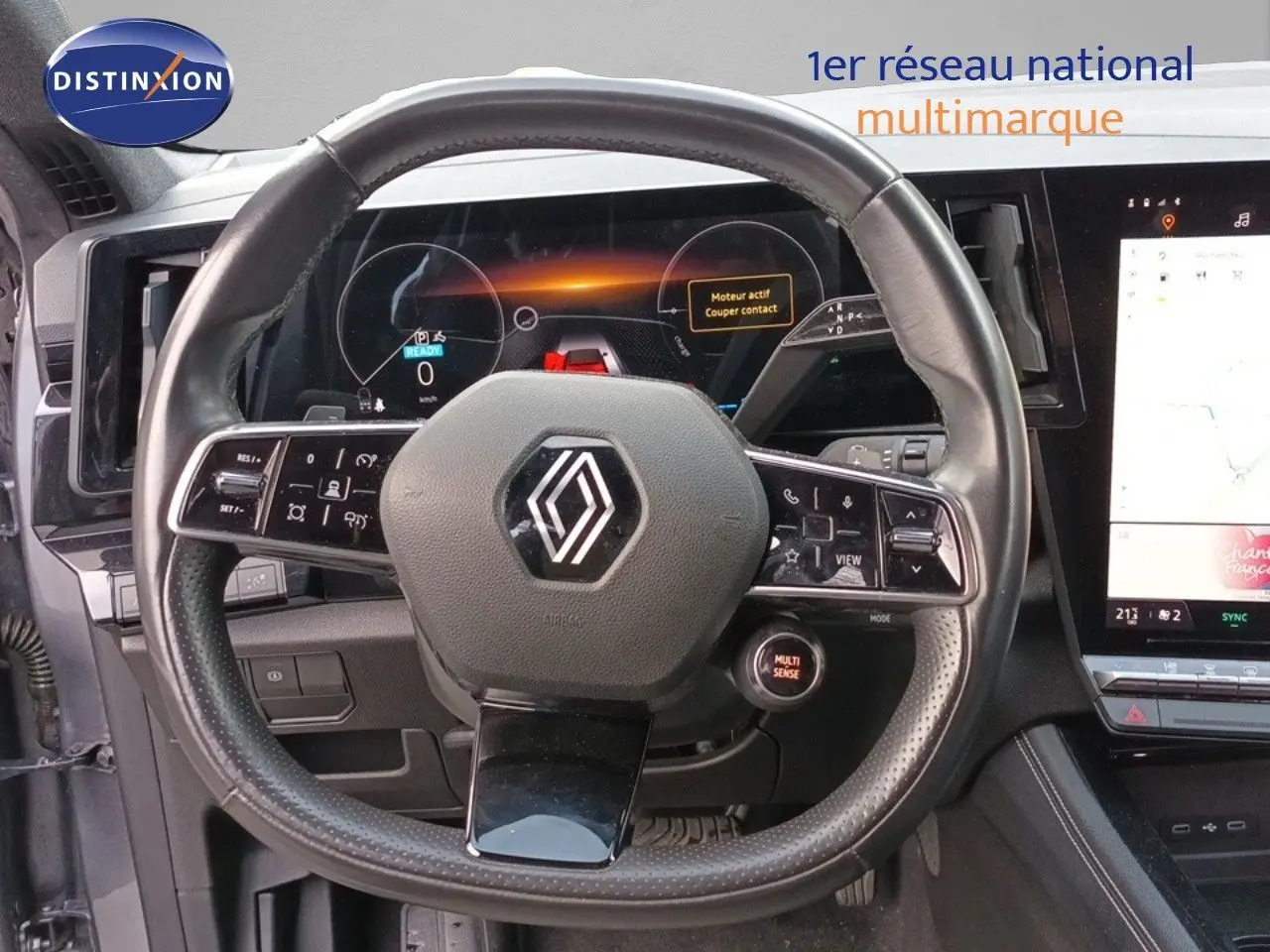 Vue rapprochée du volant cuir du Renault Espace VI hybride 2024 avec tableau de bord numérique et écran tactile.