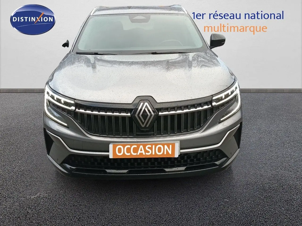 Vue frontale d'un Renault Espace gris schiste métallisé 2024 avec calandre marquée et feux LED allumés.