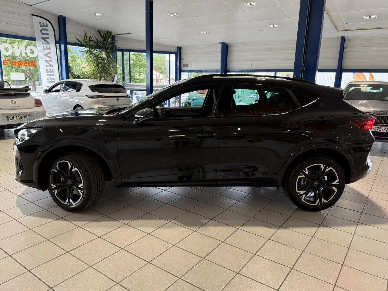 Vue de profil côté gauche d'un CUPRA Formentor 2.0 TDI noir Night avec jantes alliage 18'' en showroom.