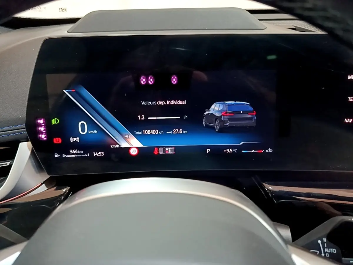 Vue rapprochée du tableau de bord numérique du BMW X1 noir 2023 affichant vitesse, autonomie et indicateurs.