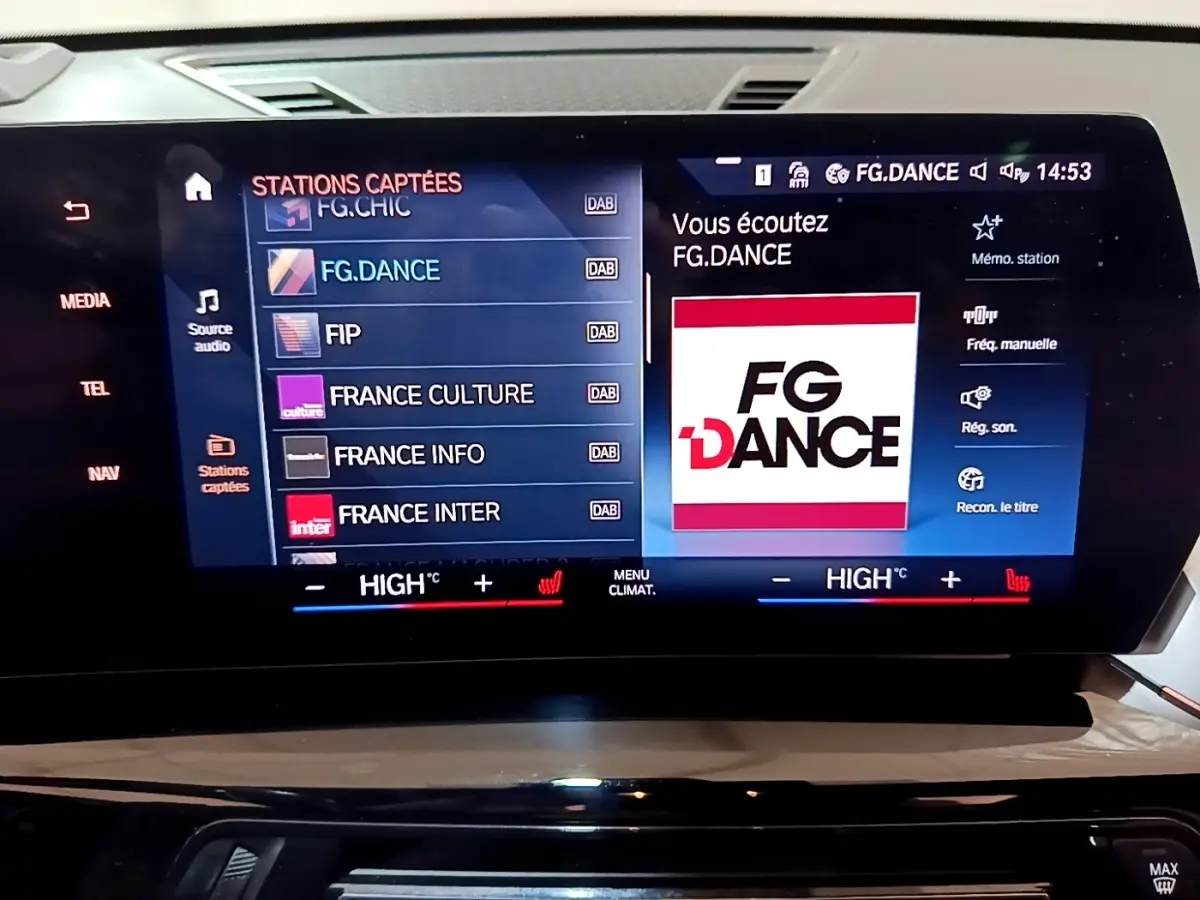 Écran tactile central du tableau de bord BMW X1 noir 2023 affichant la radio FG.DANCE et commandes climatisation.
