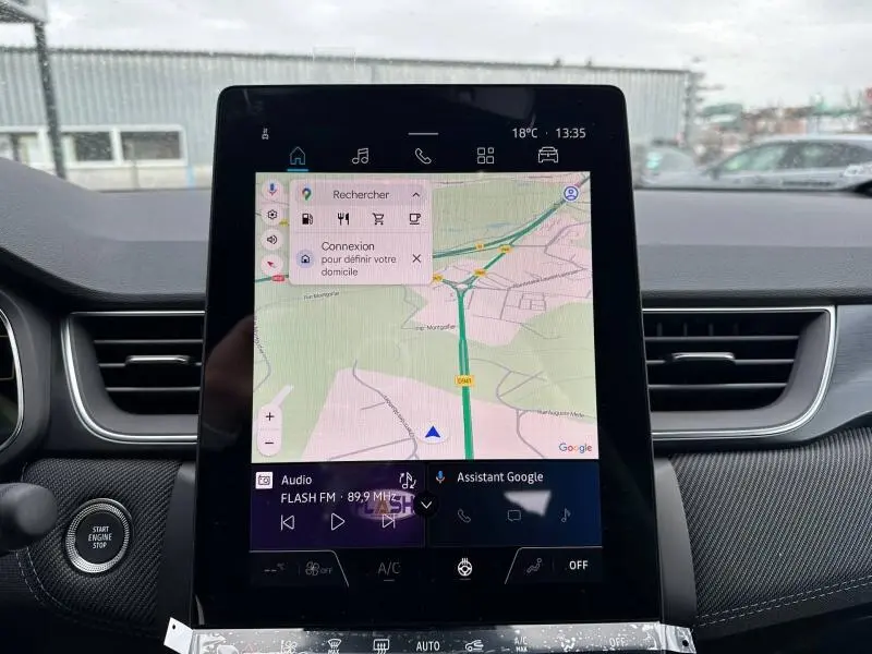 Vue intérieure centrée sur l'écran tactile du tableau de bord du Renault Captur 2026, avec navigation et commandes visibles.