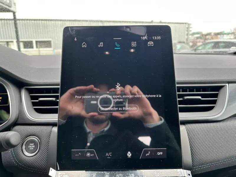 Vue intérieure centrée sur l'écran tactile du système multimédia du Renault Captur 2026 avec tableau de bord gris.