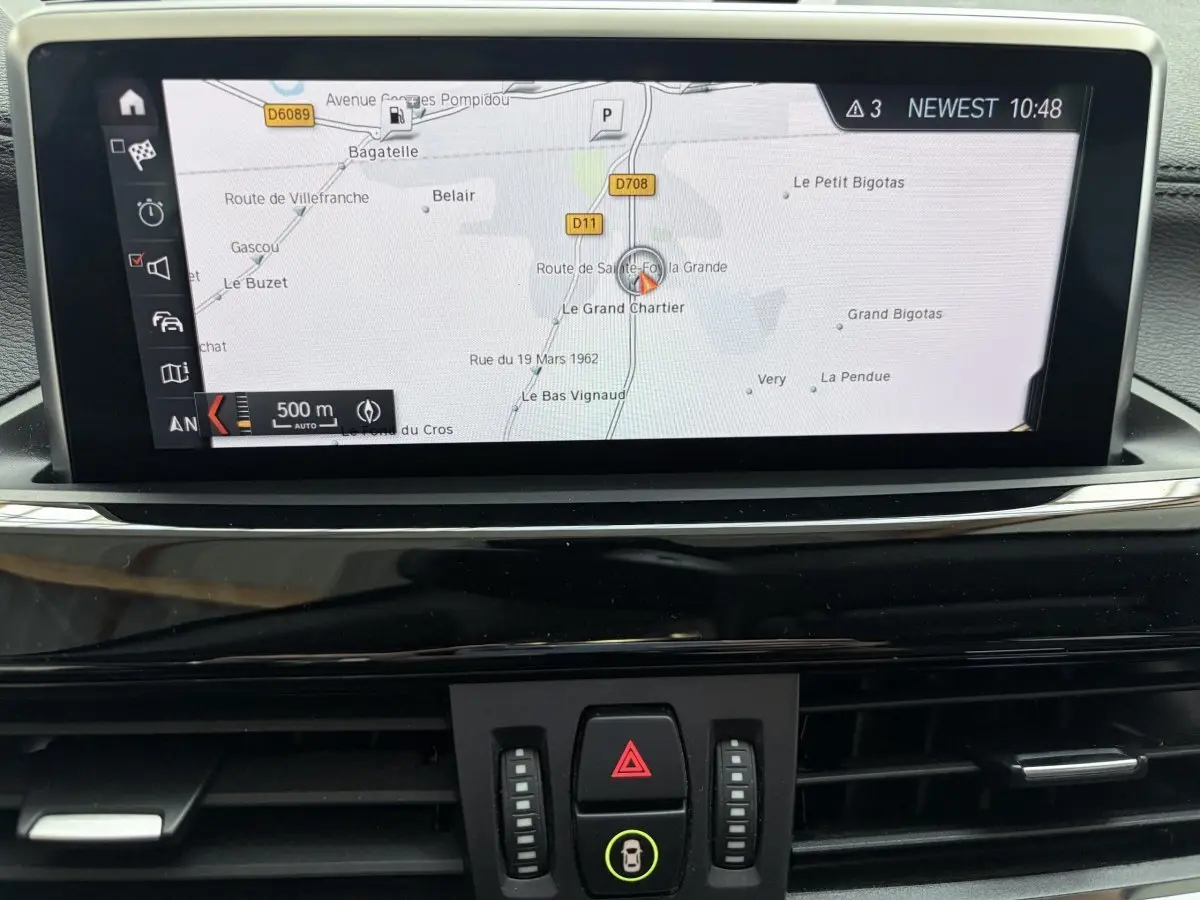 Écran tactile central du système de navigation 3D du BMW X1 xDrive25eA xLine blanc, vue intérieure frontale.