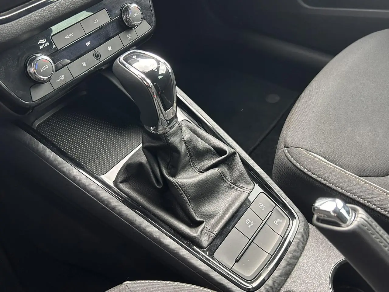 Vue rapprochée de la console centrale de la Skoda Scala TSI 116 DSG7, mettant en valeur le levier de vitesses automatique et les commandes environnantes.
