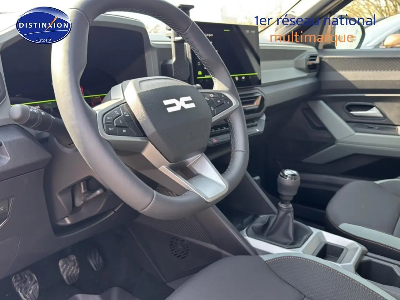 Vue intérieure côté conducteur du Dacia Bigster gris schiste, volant multifonction et levier de vitesses manuel visibles.