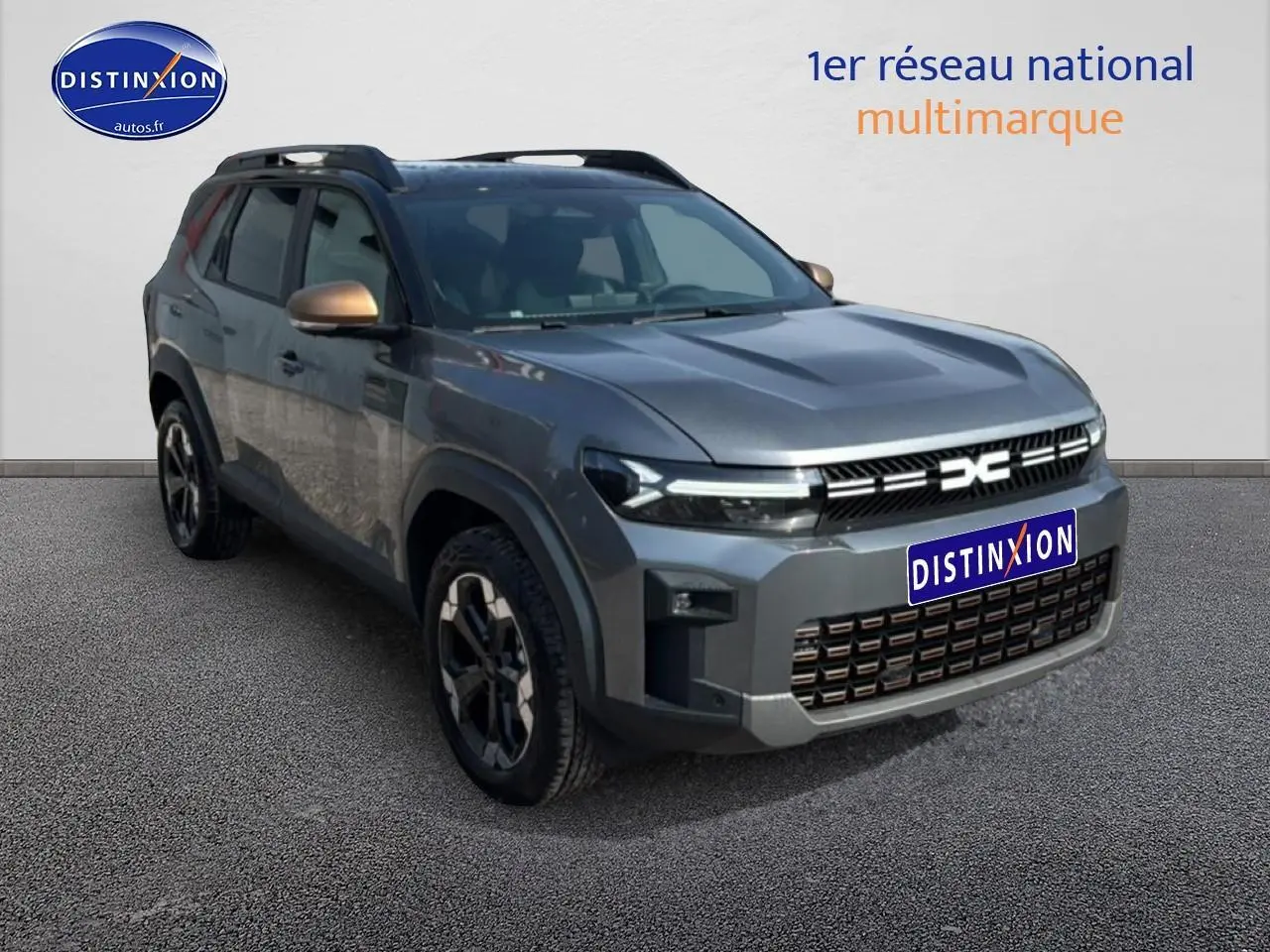 Dacia Bigster gris schiste en 3/4 avant droit, avec barres de toit et jantes alliage distinctives.