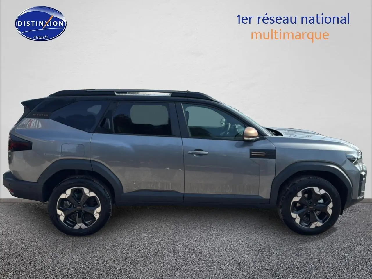 Profil droit du Dacia Bigster gris schiste avec jantes alu noires et toit noir contrasté.