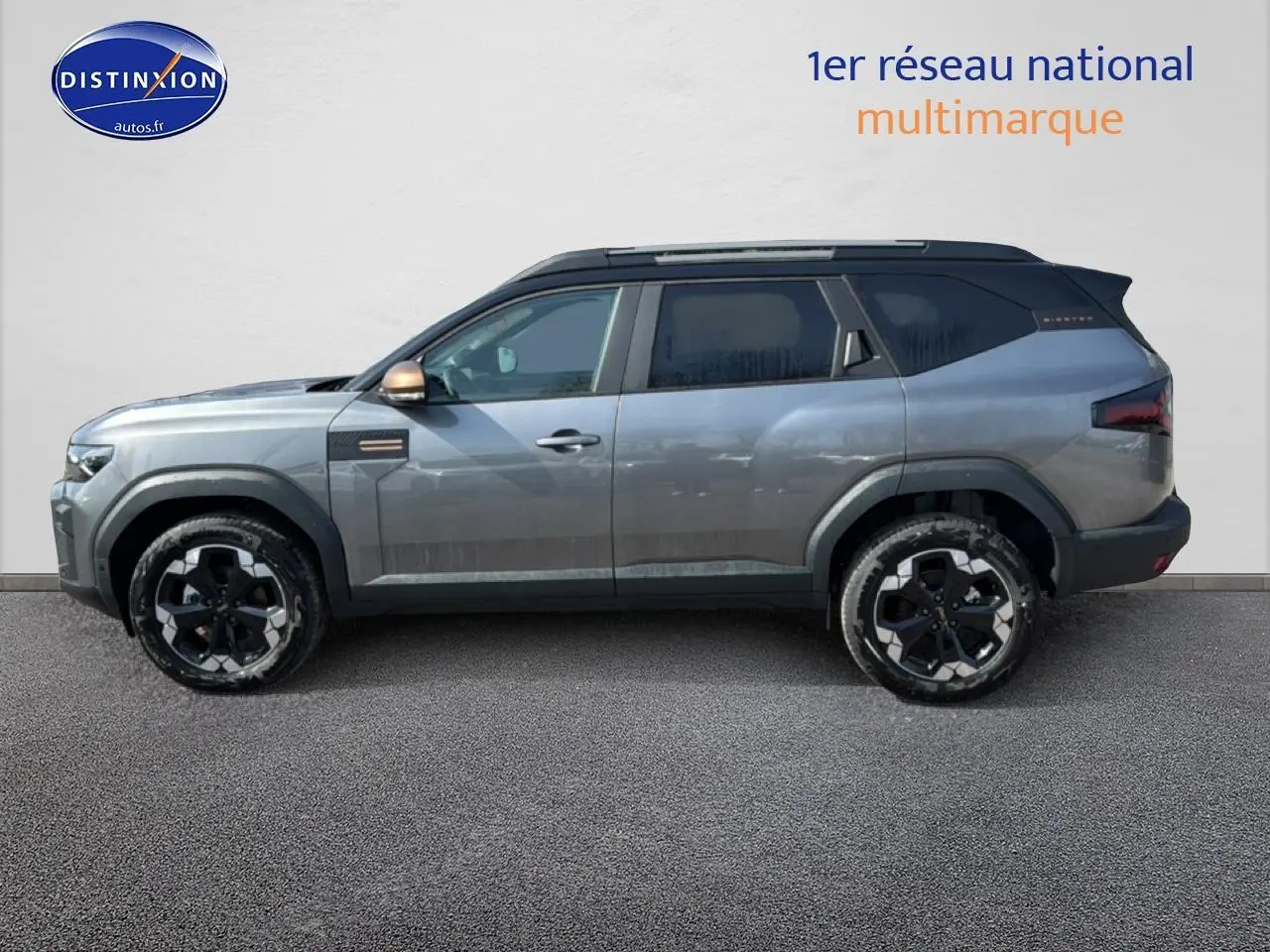 Profil droit du SUV Dacia Bigster gris schiste avec jantes noires et toit noir contrasté.