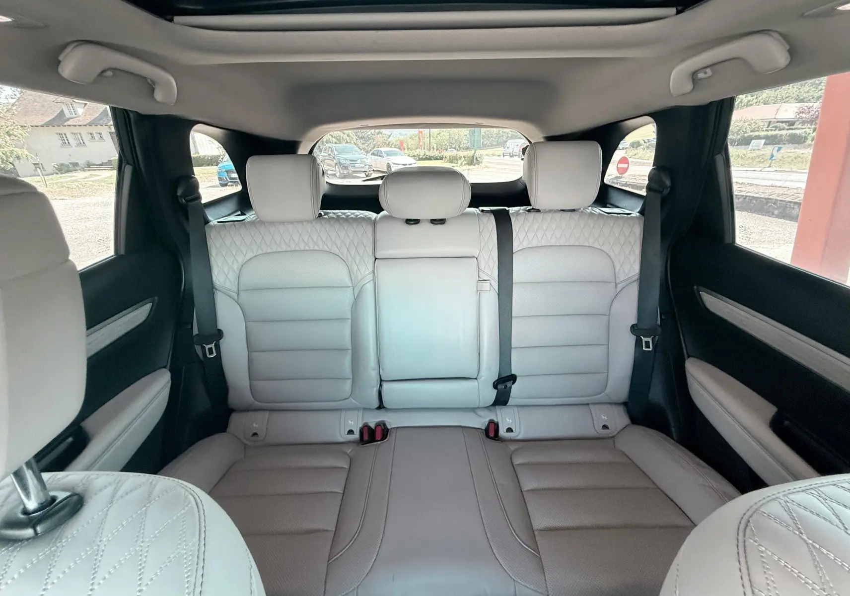 Vue intérieure arrière du Renault Koleos TCE 160 Initial Paris, sièges en cuir beige clair avec surpiqûres losanges.