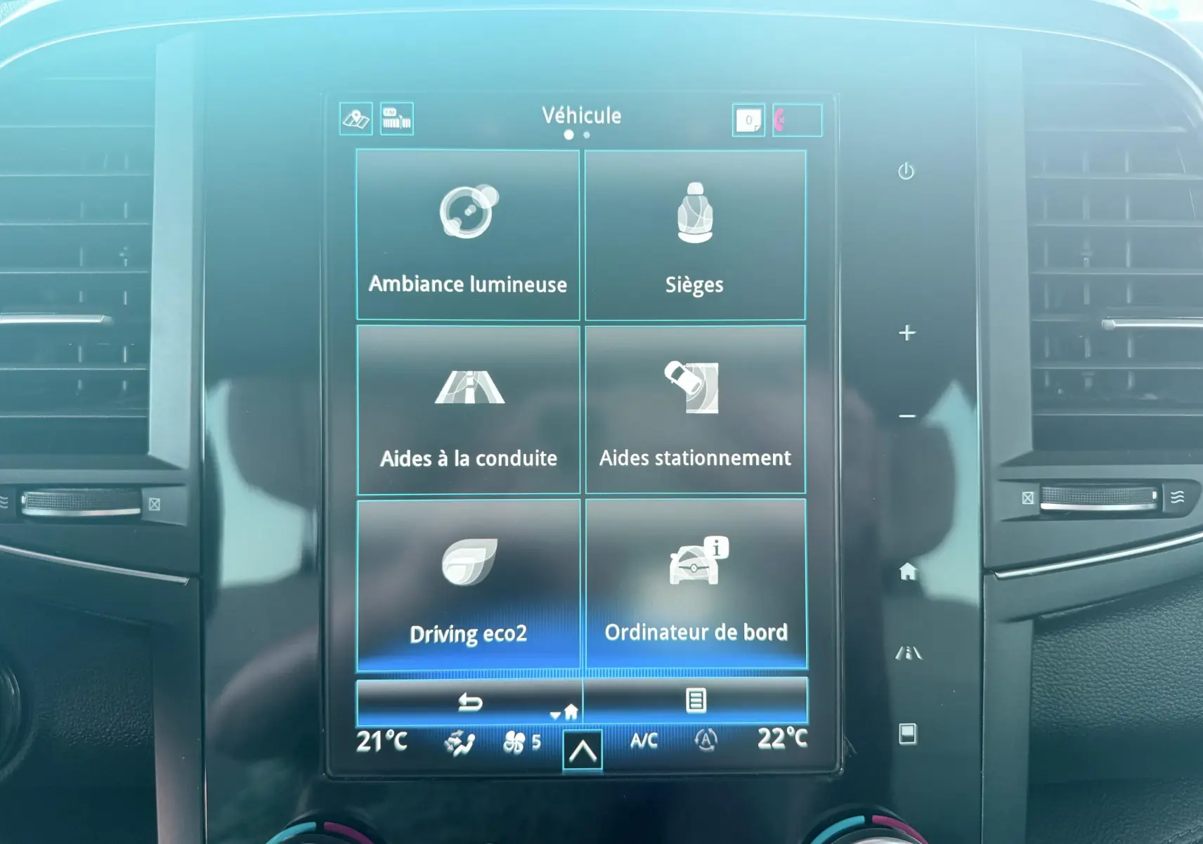 Écran tactile central du tableau de bord Renault Koleos 2021 affichant les options de véhicule et climatisation.