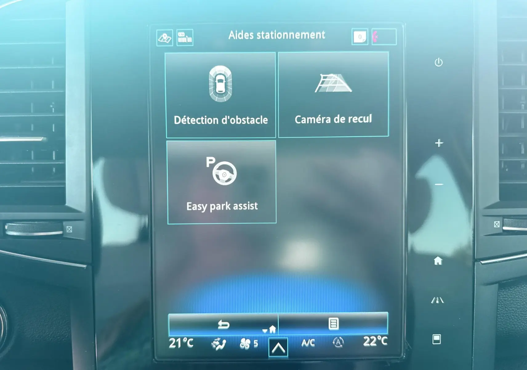 Écran tactile central du Renault Koleos 2021 affichant les aides au stationnement et la climatisation.