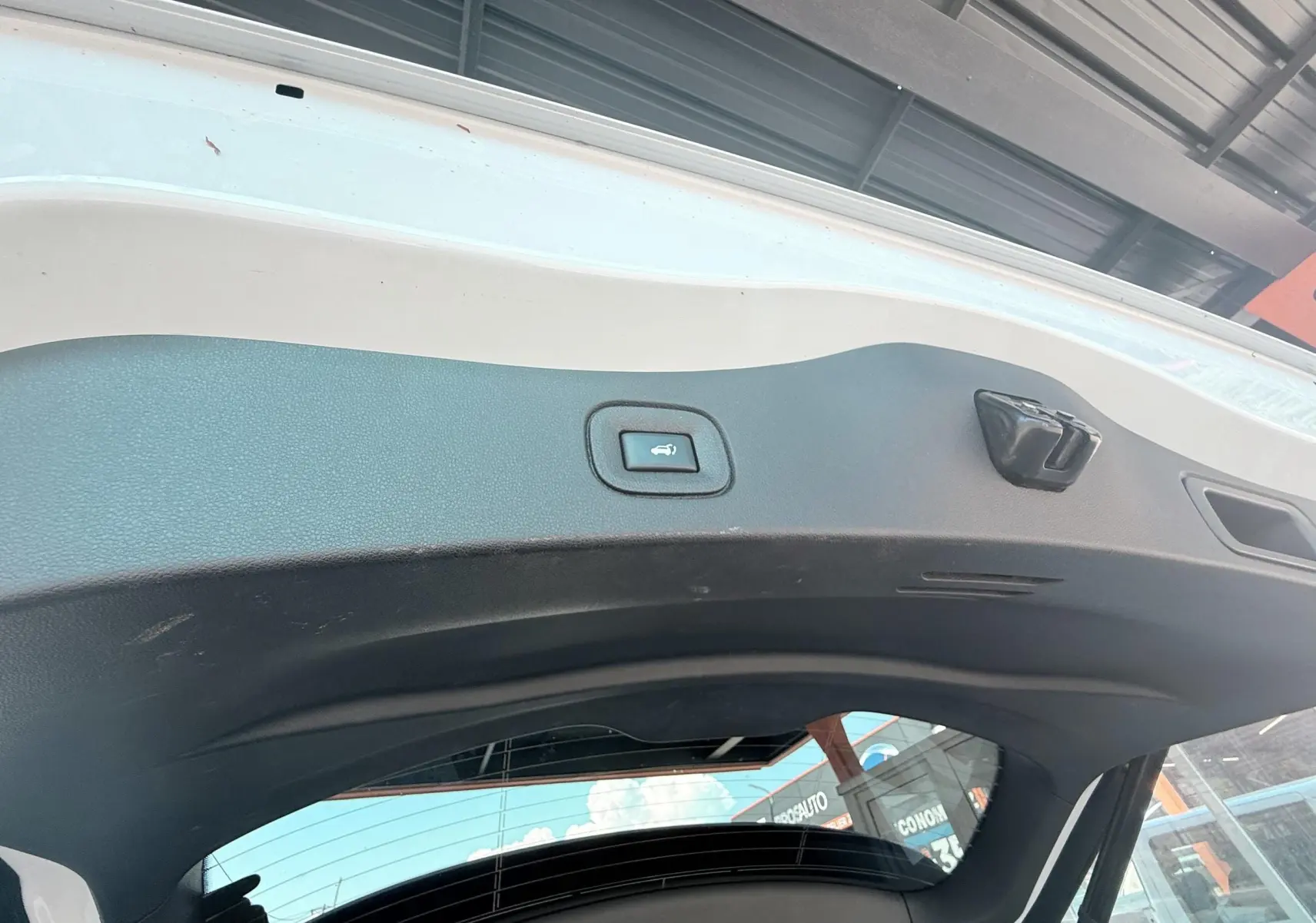 Vue intérieure du hayon blanc du Renault Koleos TCE 160 Initial Paris avec bouton d'ouverture électrique visible.