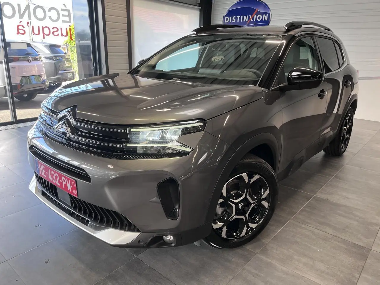 Vue 3/4 avant droit du Citroën C5 Aircross gris platinium avec jantes bi-ton et calandre noire brillante.