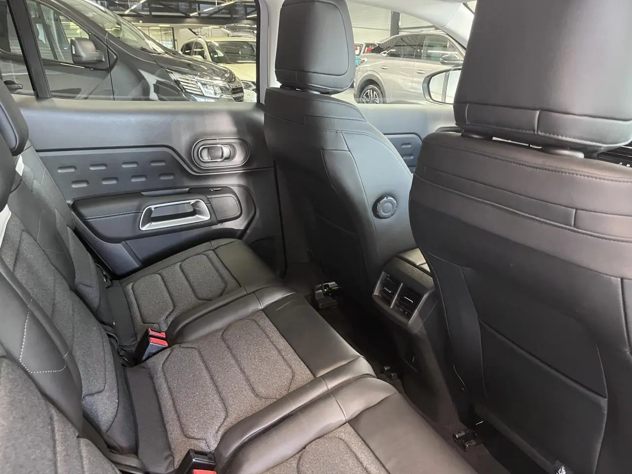Vue intérieure arrière côté droit du Citroën C5 Aircross gris, sièges tissu et cuir noir avec surpiqûres.