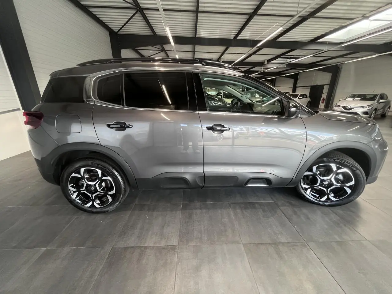 Vue latérale droite d'un Citroën C5 Aircross gris platinium avec jantes alliage bi-ton et vitres surteintées.