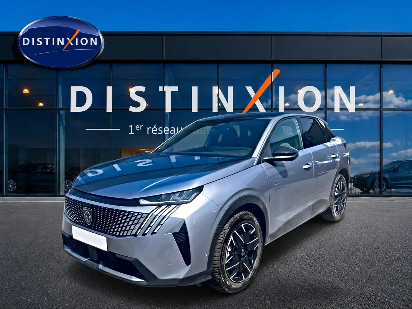 Peugeot 3008 gris en 3/4 avant droit, avec calandre distinctive et jantes alliage noires devant showroom Distinxion.