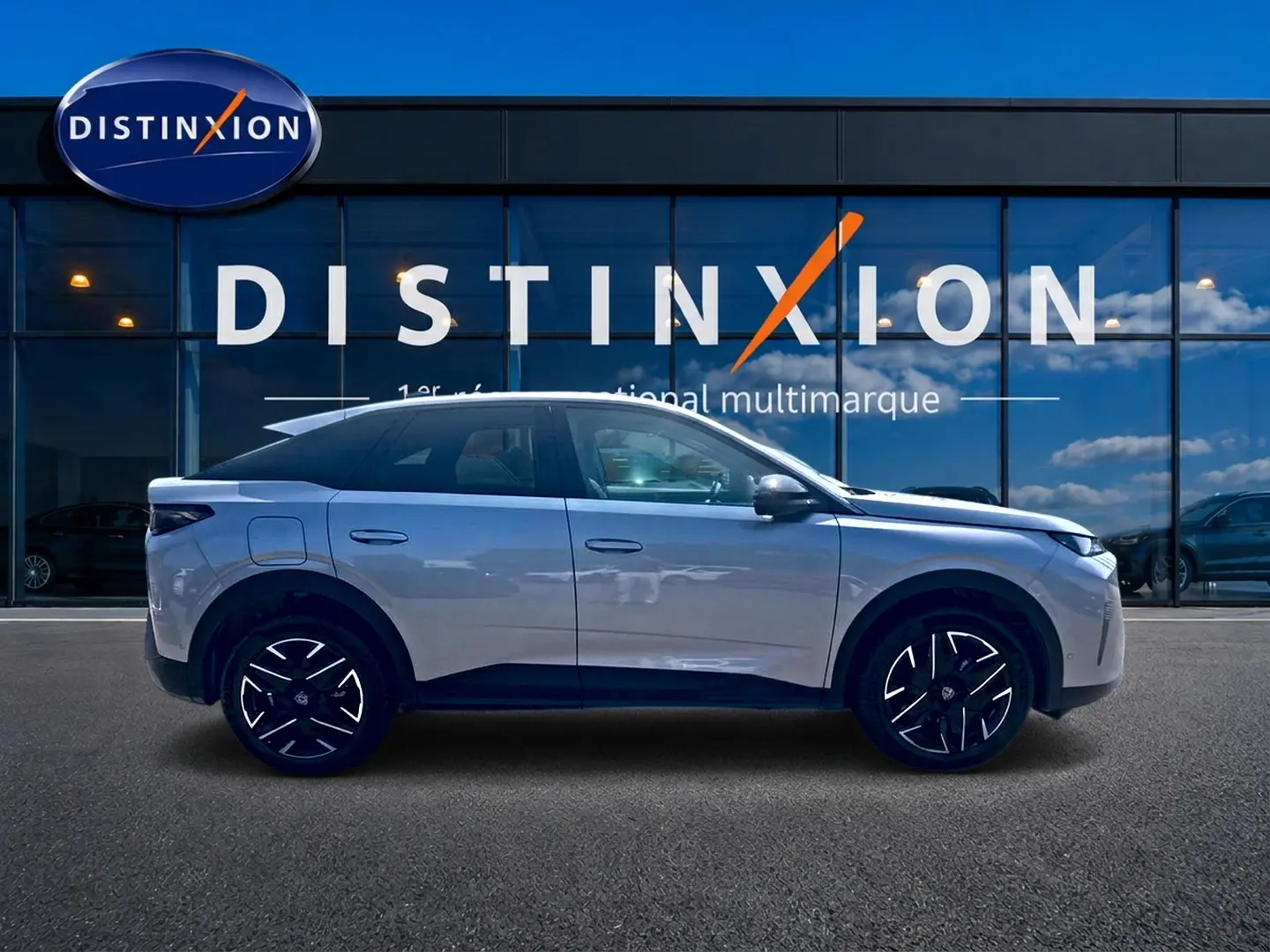 Vue latérale droite du Peugeot 3008 gris 2025 avec jantes alliage noires devant une vitrine Distinxion.