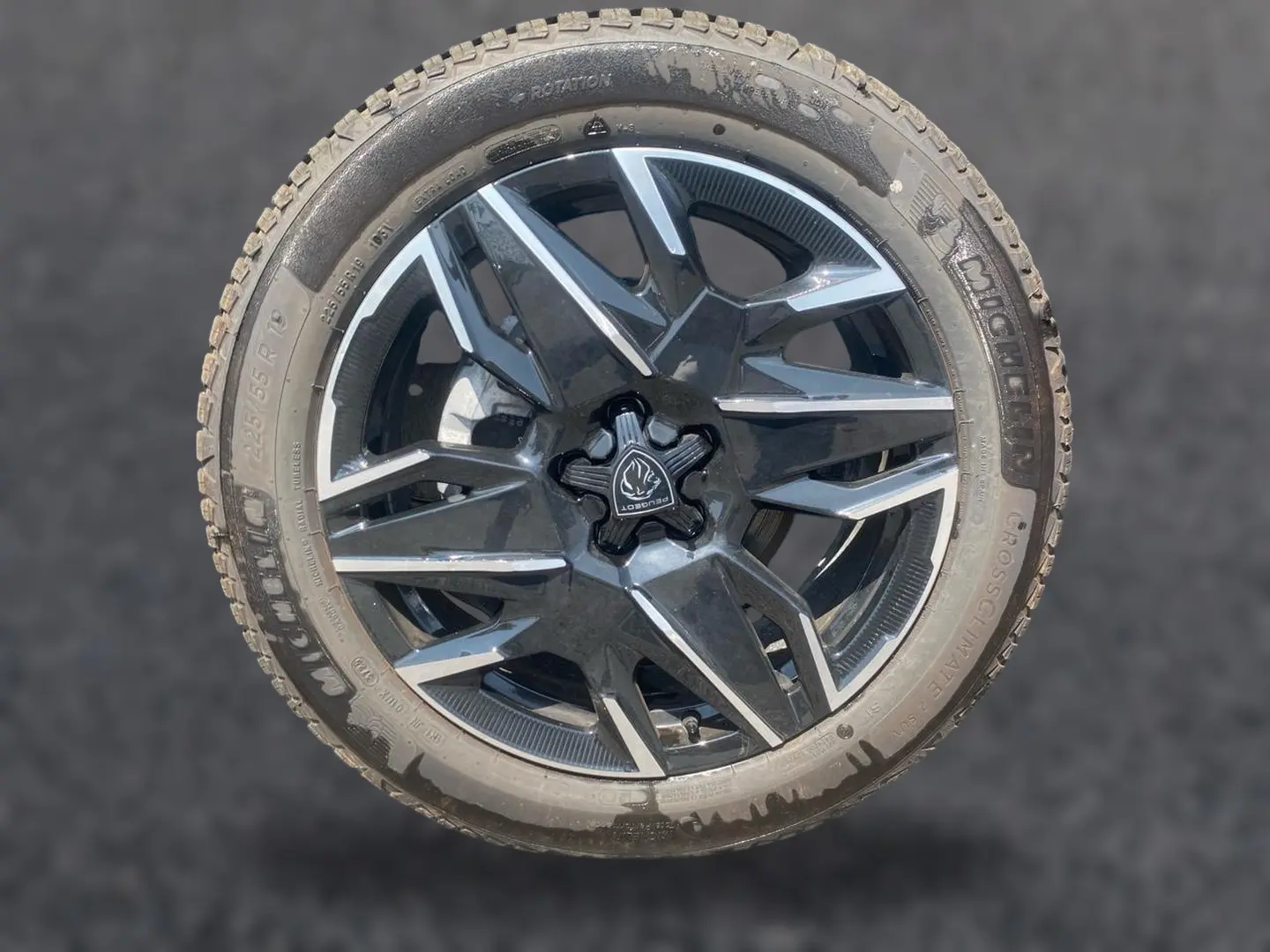 Gros plan sur une jante alu noire et grise de Peugeot 3008 1.2 hybrid 145 allure business, avec pneu Michelin.