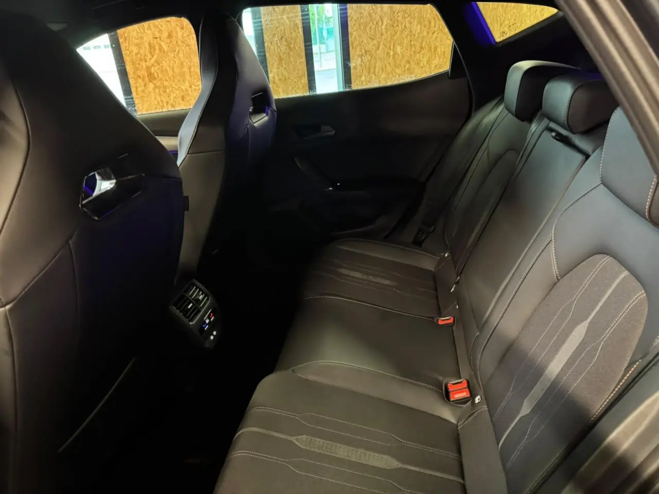 Vue intérieure arrière du CUPRA Formentor 2024 avec sièges baquets en textile noir Asphalte et surpiqûres contrastantes.