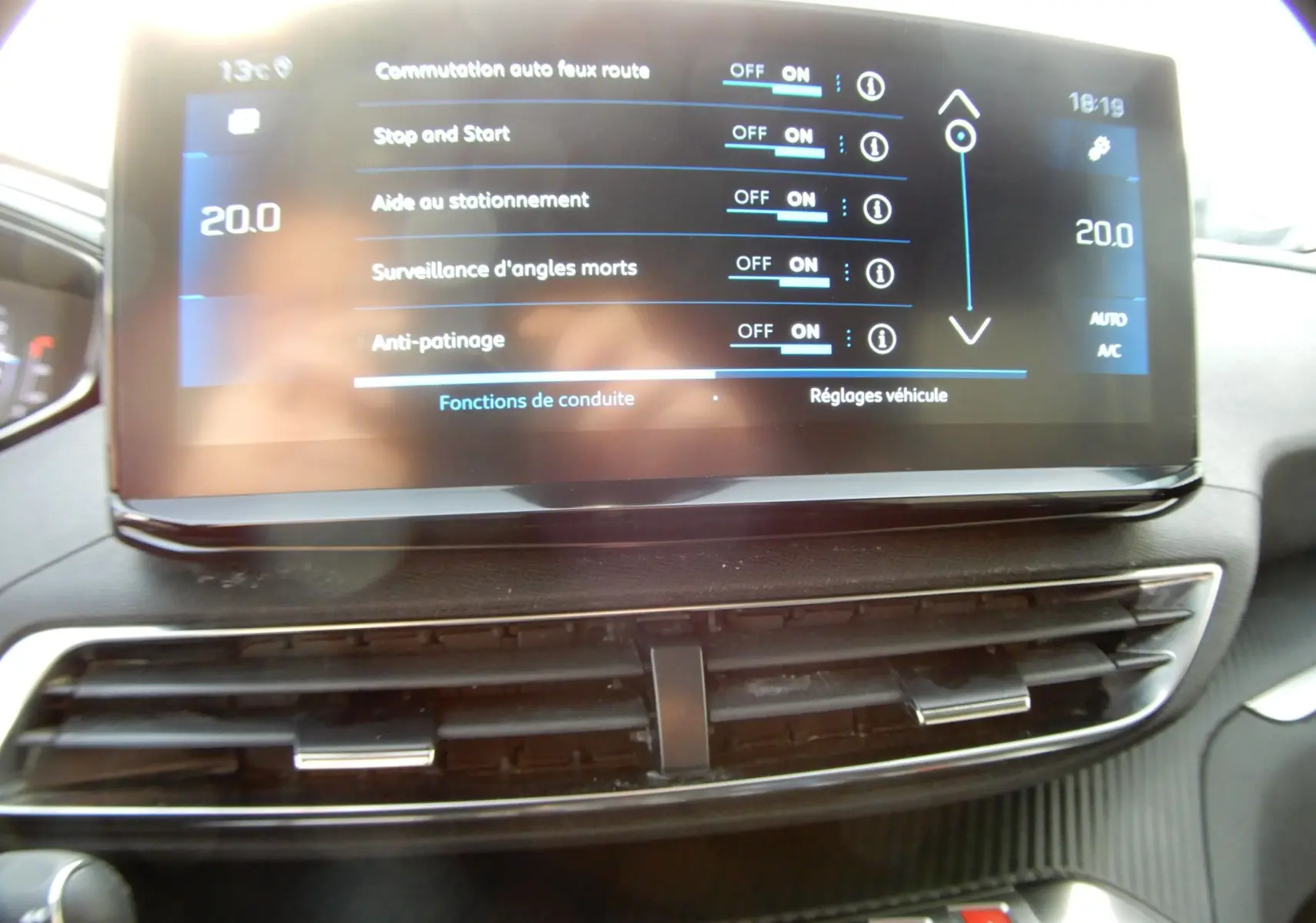 Écran tactile du tableau de bord du Peugeot 5008 blanc nacré, affichant les réglages d'aides à la conduite.