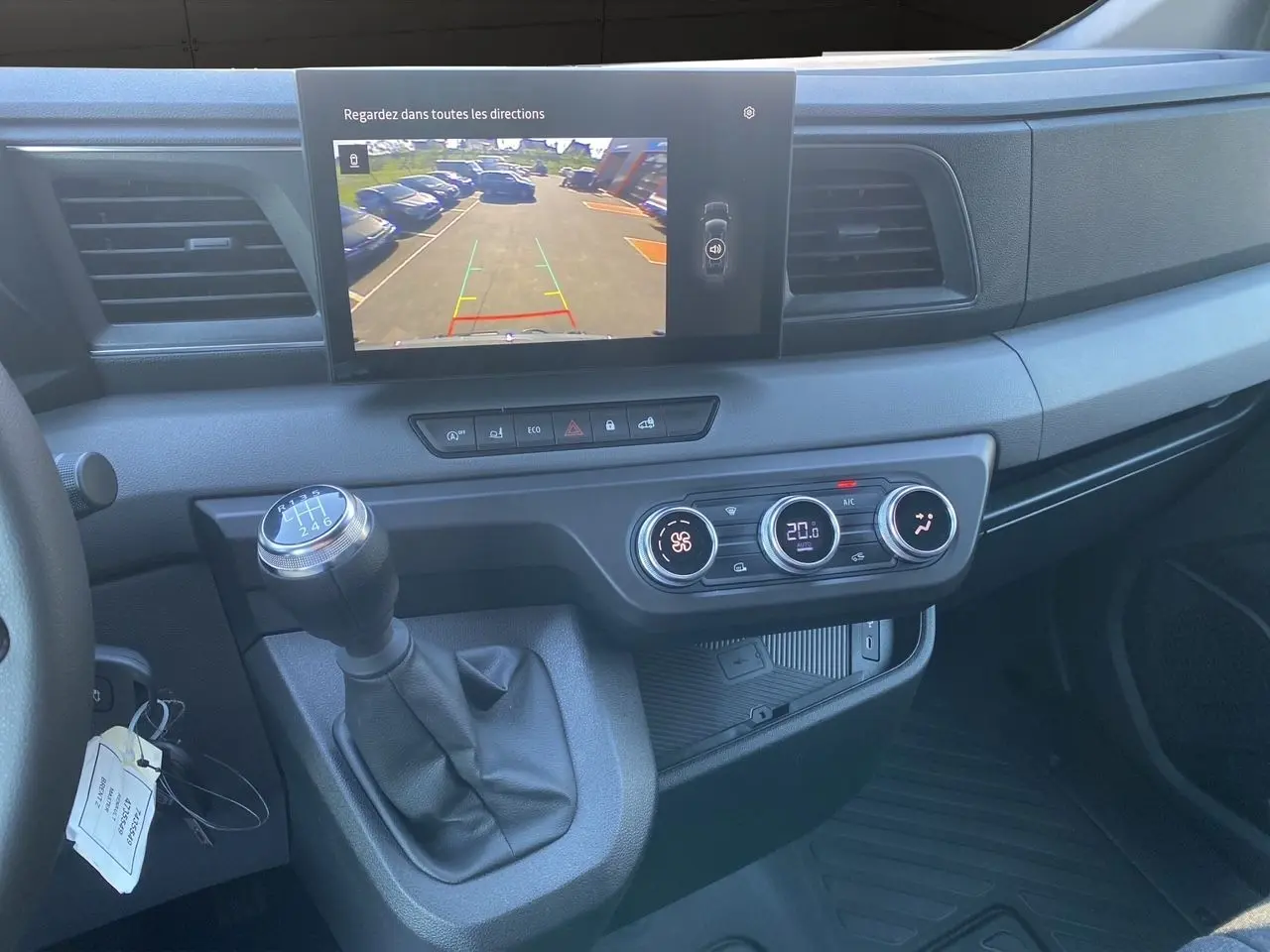 Vue intérieure du tableau de bord du Renault Master 2025 gris urbain, avec écran caméra de recul et levier de vitesses manuel.